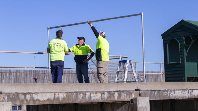 Workers assess the pier. Picture: Wayne Taylor