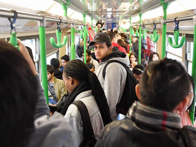 Passangers ride a crowded tram through Swanston Street in Mlebourne's CBD. Picture: Jake Nowakowski