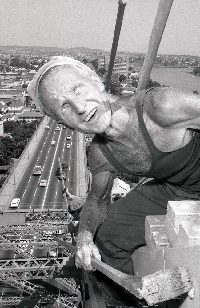 Painting is an endless job for Mr Tom Daly, of New Farm, seen here in 1968, wielding his long-handled brush at the top of the 300-foot-high southern span of the Story Bridge, applying red paint to the iron work. Each application of paint takes five years, and Mr Daly is on his fifth trip across the bridge in 23 years.