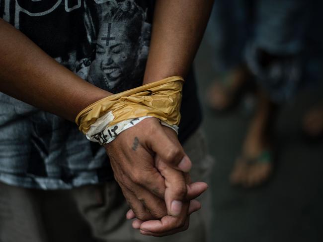 A man with his hands bound was among men who were rounded up for verification after police officers conducted a large scale anti-drug raid at a slum community in Manila in July this year. Picture: Noel Celis/AFP