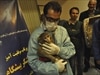 An Iranian technician holds a monkey