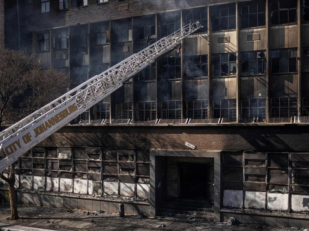 A ladder from a fire engine is pictured reaching into a burned apartment block in Johannesburg. (Photo by Michele Spatari / AFP)