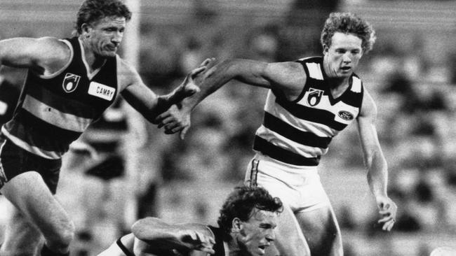 Geelong's Garry Hocking and Adelaide's Chris McDermott prepare to pounce on the loose ball ahead of Darel Hart.