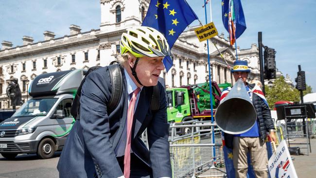 Pro-Brexit Conservative MP Boris Johnson rides his bicycle as he arrives at the Houses of Parliament in London on May 15, 2019. (Photo by Tolga AKMEN / AFP)