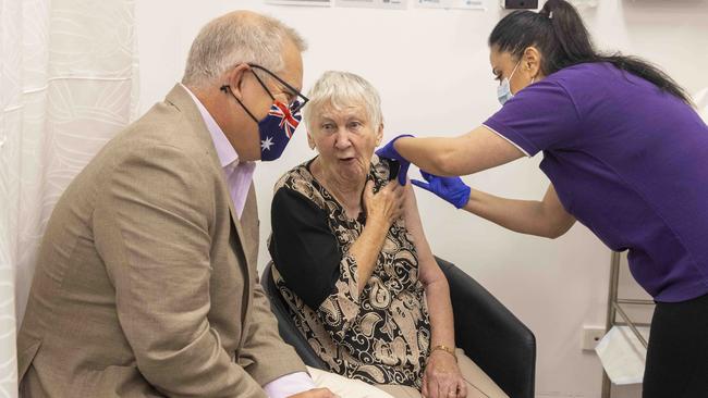 Prime Minister Scott Morrison is seen talking to the first vaccine recipient Jane Malysiak as she receives her jab at Castle Hill Medical Centre in Sydney.