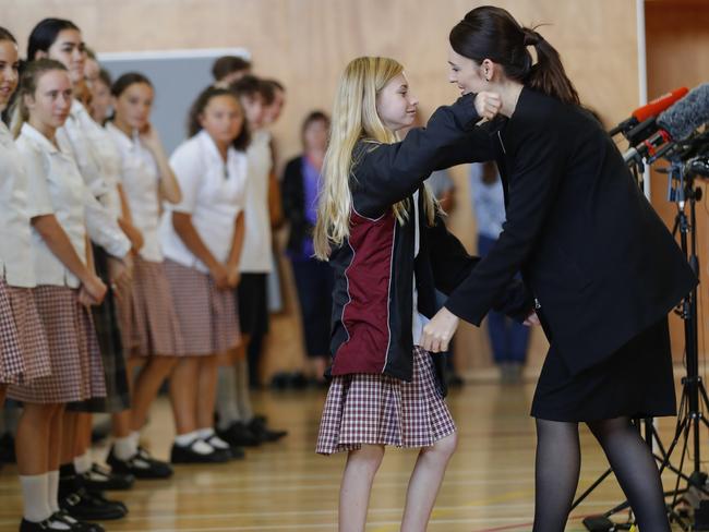 Jacinda Ardern, right, hugs and consoles a student during a high school visit. Picture: AP Photo/Vincent Thian