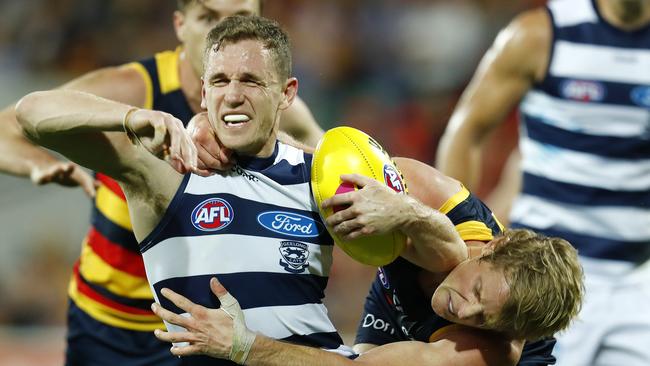 Geelong's Joel Selwood gets tackled high by Adelaide's Rory Sloane. Picture: Michael Klein