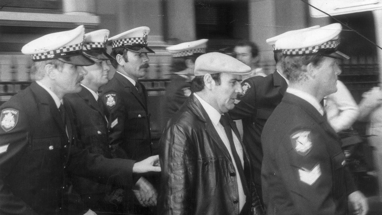 Gianfranco Tizzoni being escorted by police.