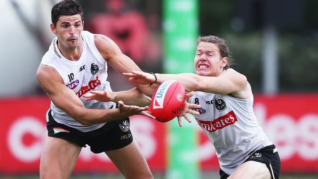 Tom Langdon competes with Magpies skipper Scott Pendlebury at training.