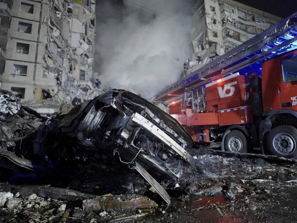 A destroyed car and a residential building that were hit by a missile strike in Dnipro. Picture: AFP