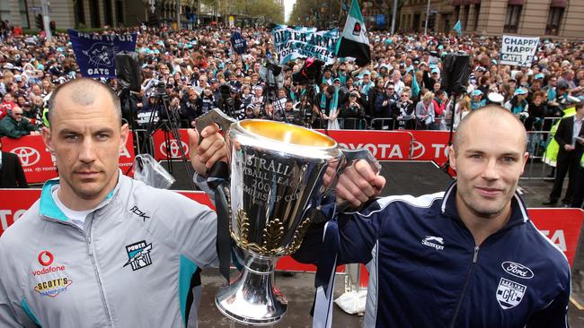 A very serious Warren Tredrea holding AFL Premiership cup with Tom Harley at the parade in 2007.