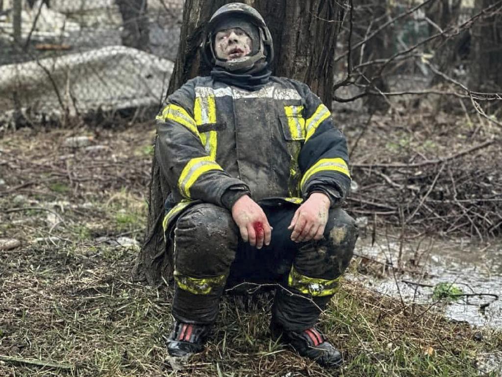 An injured Ukranian rescuer rests next to a tree following a missile attack in Odessa. Picture: Ukranian Emergency Service/AFP