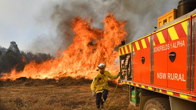 New South Wales Rural Fire Service firefighters are seen back burning and fighting fires on Long Gully Road in the northern New South Wales town of Drake, Monday, September 9, 2019. A number of homes have been destroyed by bushfires in northern New South Wales and Queensland. (AAP Image/Darren England) NO ARCHIVING