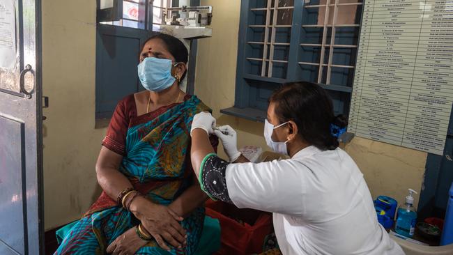 MYSURU, INDIA: Indramma, 55, gets inoculated with AstraZeneca-Oxford's Covishield vaccine against COVID-19 at a public health centre. India's prolonged and debilitating wave of infections has reached deep into rural India. Photo by Abhishek Chinnappa/Getty Images