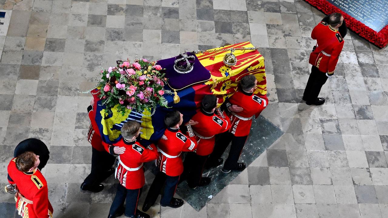 The coffin of Queen Elizabeth II, draped in the Royal Standard with the Imperial State Crown and the Sovereign's orb and sceptre, is carried in to Westminster Abbey.