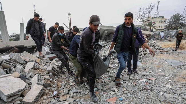 Gazans recover the body of a child from a destroyed building following Israeli air strikes on Rafah, Gaza. Picture: Getty Images.