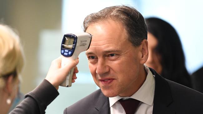 Federal Health Minister Greg Hunt has his temperature checked before touring the Royal Melbourne Hospital in Melbourne on Thursday. Picture: AAP