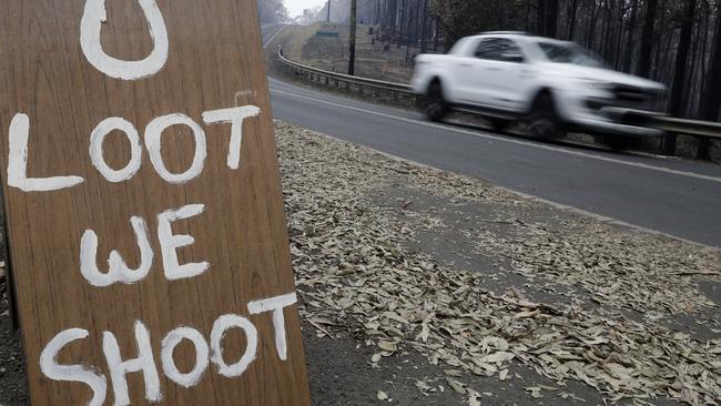 A sign discourages looters near Conjola Park, NSW. Photo: Rick Rycroft/AAP