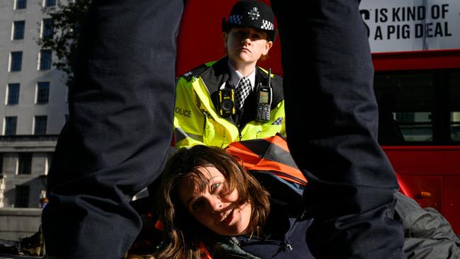 Police officers arrest a Just Stop Oil protester in London.