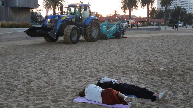 People sleep on St Kilda Beach after New Year’s Eve celebrations. Picture: David Crosling