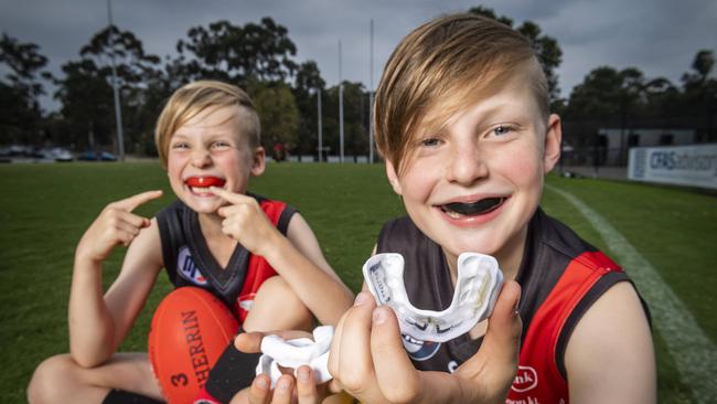 Harper, 8 and Jonah, 10, show off the hi-tech mouthguards that can help monitor head knocks. Picture: Jake Nowakowski.