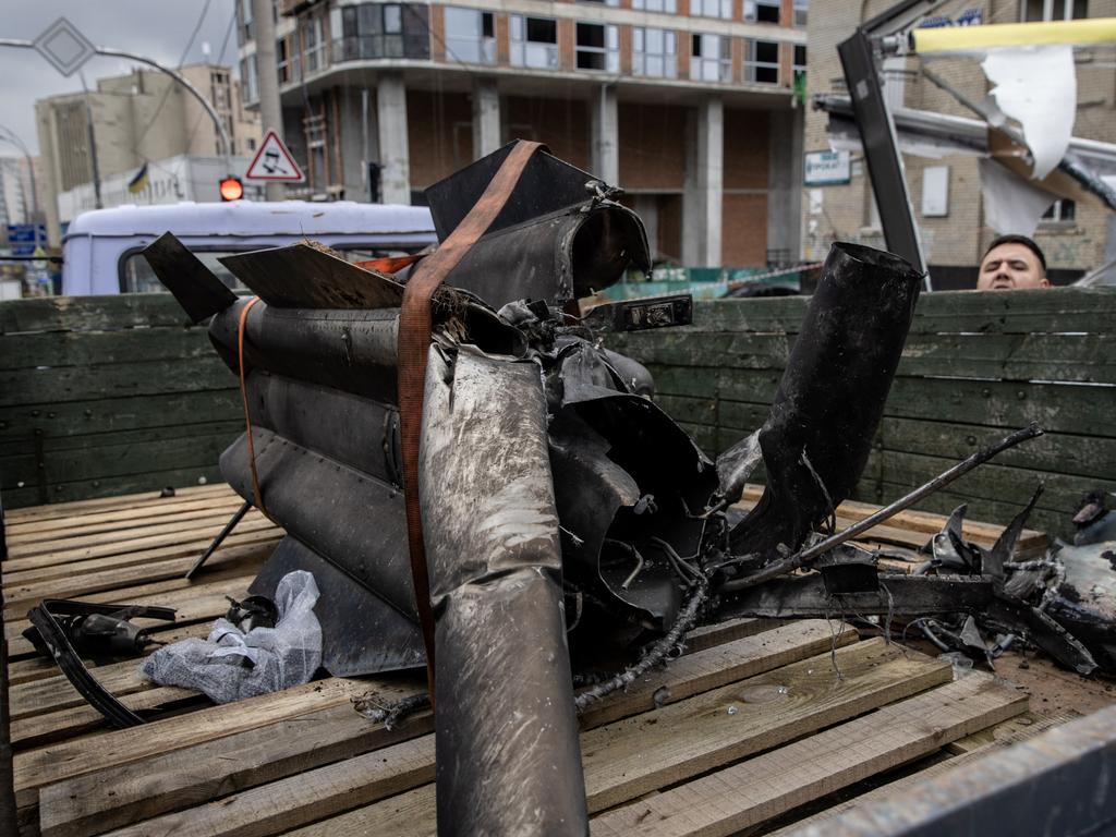 A man looks at the remains of a rocket as it is cleared away on the back of a truck in Kyiv. Picture: Getty