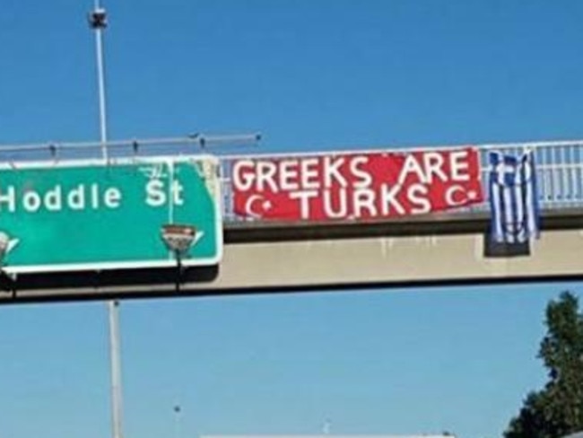 A defaced Greek flag was hung from a busy Melbourne freeway last week.