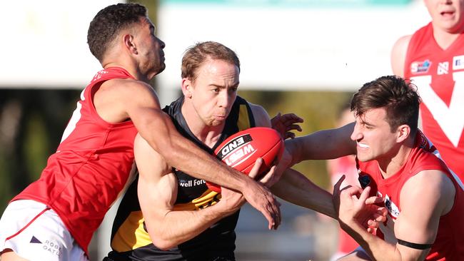 Tiger Alex Martini feels the heat as he is gang-tackled by North Adelaide’s Kym LeBois (left) and Thomas Schwarz. Picture: Sarah Reed