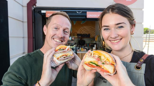 Good Neighbour Deli owner Brett Hicks-Maitland and sandwich pro Niamh Montague with a ham, cheese and salad double cut roll. Picture: Brenton Edwards