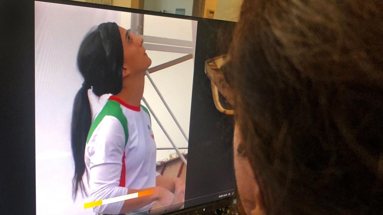 A woman looks at a screen displaying a video of an international climbing competition is Seoul, South Korea, during which Iranian climber Elnaz Rekabi competes without a hijab, in the Cypriot capital Nicosia on October 18, 2022. (Photo by AFP)