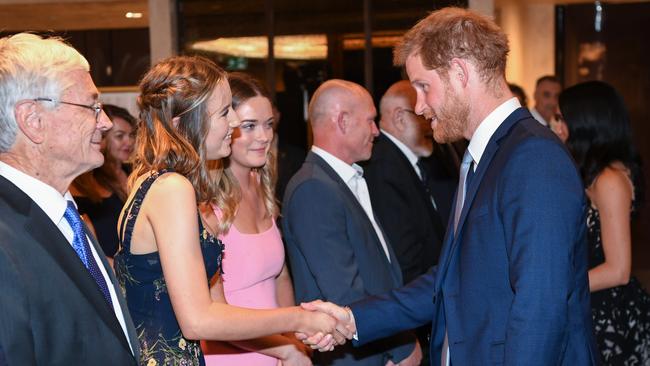 Sophia shakes hands with Prince Harry while Dick Smith looks on.