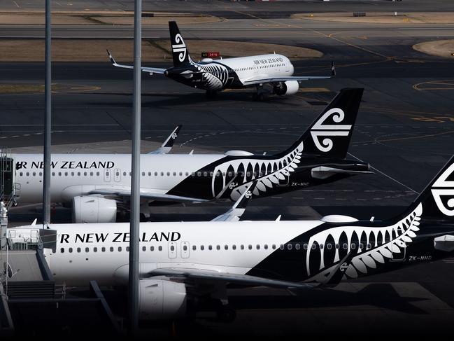 Air New Zealand airplanes wait for passengers outside the international terminal as a plane taxis at Wellington International airport on February 20, 2020. - The New Zealand government announced a bail out package to help the national carrier Air New Zealand survive the Corvid 19 virus down turn. (Photo by Marty MELVILLE / AFP)