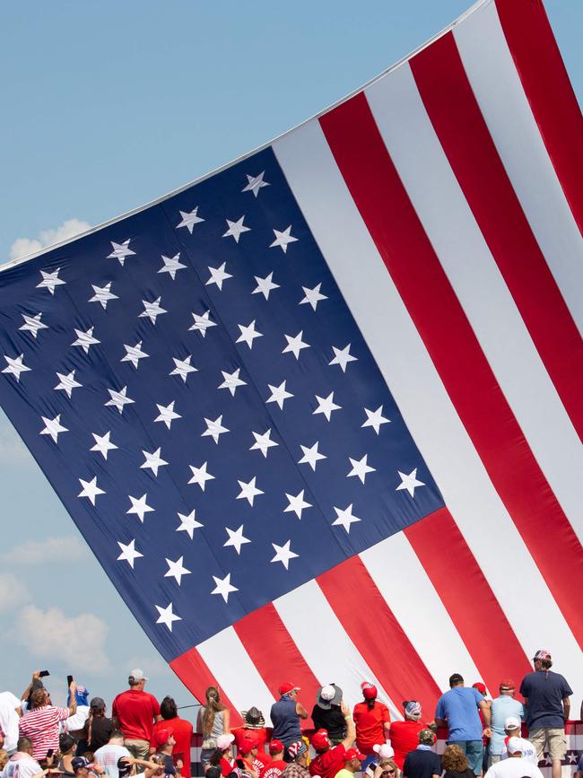 Donald Trump supporters cheer as the American flag is untangled before he speaks. Picture: Rebecca Droke/AFP