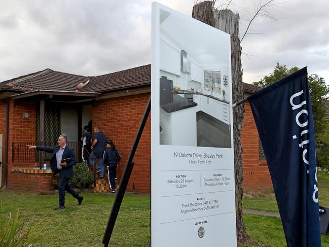 Real estate story on suburbs where house prices are dropping. McGrath real estate agent Frank Bartolone pictured showing potential buyers through an open home in Bossley Park. Picture: Toby Zerna