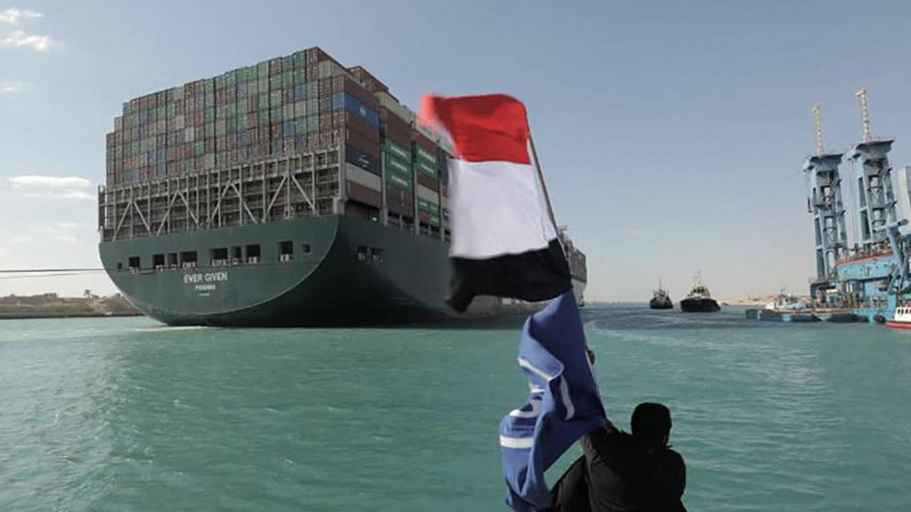 A man waves the Egyptian flag after the container ship Ever Given is fully dislodged from the banks of the Suez Canal. Picture: Suez Canal Authority/AFP
