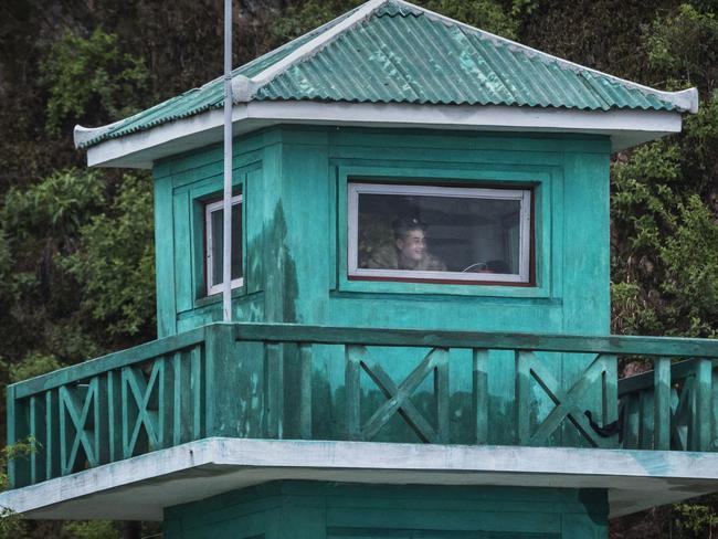 A DPRK soldier watches from a tower on the Yalu river north of the border city of Dandong, Liaoning province, northern China near Sinuiju, North Korea. Picture: Kevin Frayer/Getty Images