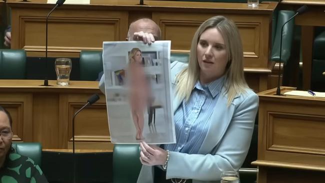 Laura McClure holds up doctored nude image of herself. Picture: YouTube / ACT New Zealand