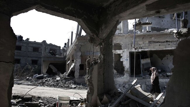 A Palestinian woman walked past destroyed buildings in a Gaza Strip city in August 2014. Picture: AFP/Getty Images