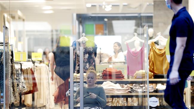 A Portmans staff member, who is now out of a job, chains the door shut at the fashion brand’s store in Sydney’s CBD. Picture: Nikki Short