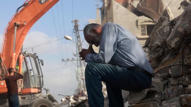 A Palestinian man wait for news of his daughter as rescue workers search for survivors under the rubble of a building hit in an overnight Israeli bombing in Rafah.