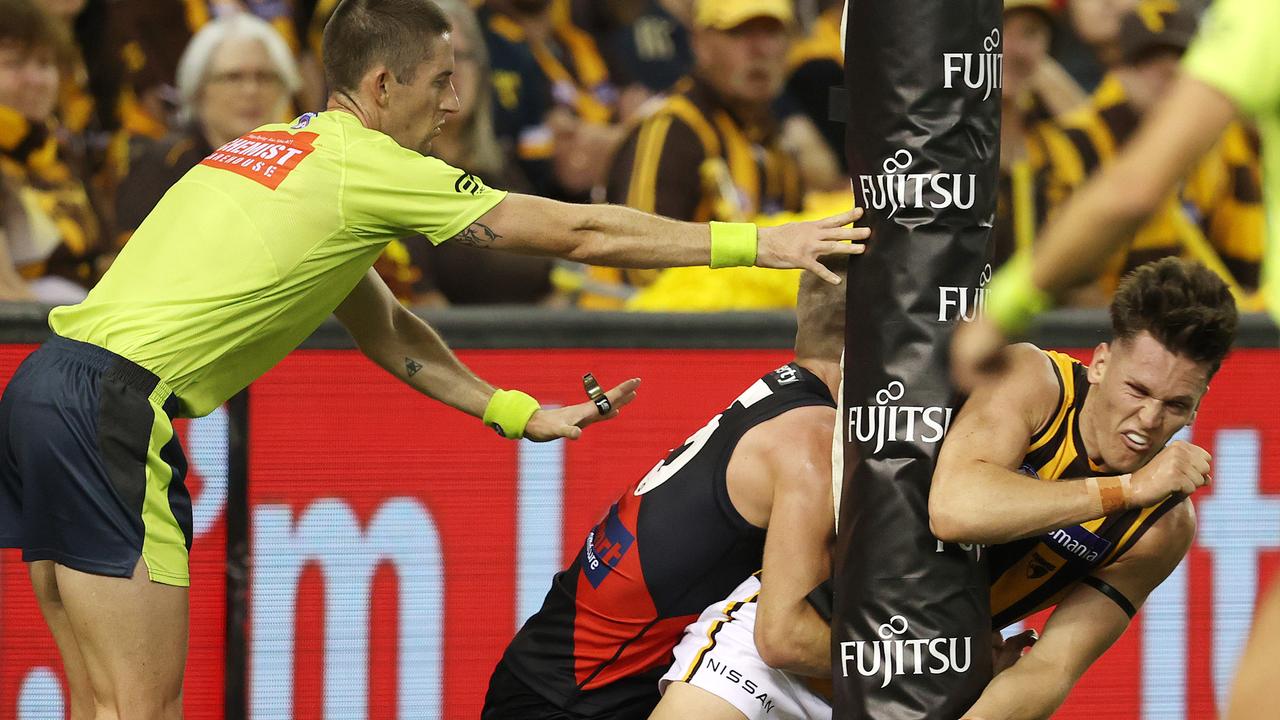 Jacob Koschitzke of the Hawks collides with the point post as he handballs clear . Pic: Michael Klein