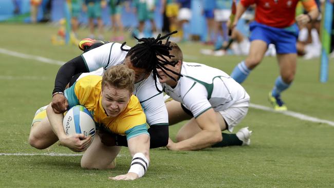 Australia's Henry Hutchison, front, scores a try during the men's rugby sevens match.