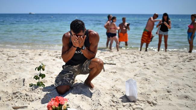A man breaks down after laying flowers on Marhaba beach where 38 people were killed on Friday.