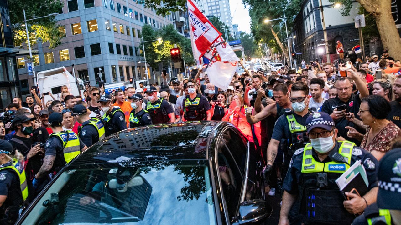 A car believed to be carrying Novak Djokovic is escorted by police as fans surround the vehicle in Collins Street. Picture: Getty Images