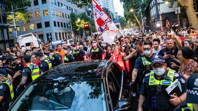 A car believed to be carrying Novak Djokovic is escorted by police as fans surround the vehicle in Collins Street. Picture: Getty Images