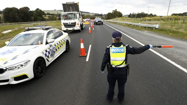 Police perform checks at a roadblock on the Calder Highway just before Gisborne outside Melbourne on Thursday. Picture: Darrian Traynor/Getty Images