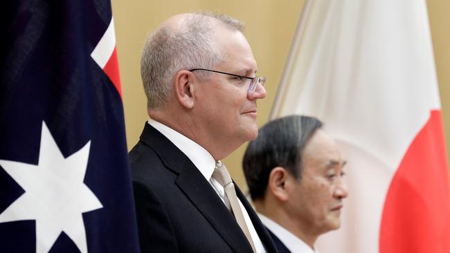 Australia's Prime Minister Scott Morrison (L) and Japan's Prime Minister Yoshihide Suga observe an honour guard during a welcoming ceremony ahead of their meeting at Suga's official residence in Tokyo.