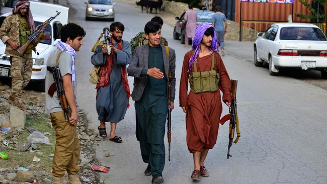 Afghan armed men, supporting the Afghan security forces against the Taliban, walk along a road in Bazarak, Panjshir province. Picture: AFP