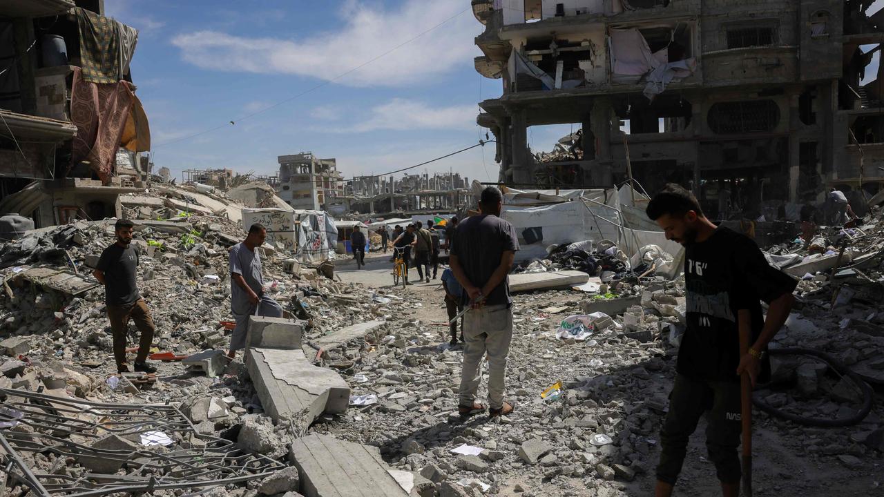 People inspect the damage amid the rubble of a building hit in an Israeli strike in Jabalia in the northern Gaza Strip on May 15, 2025. (Photo by BASHAR TALEB / AFP)