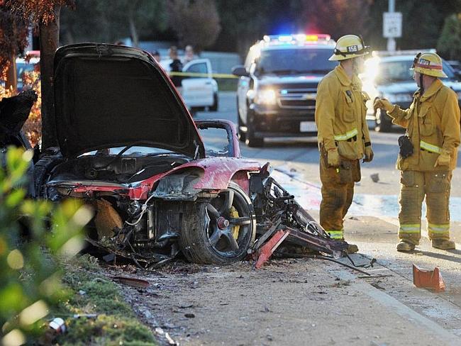 Sheriff's deputies work near the wreckage of the Porsche Paul Walker was travelling in.